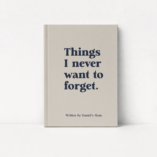 A hardcover boy mom keepsake journal with a light beige cover standing upright against a white background. The cover features the text 'Things I never want to forget.