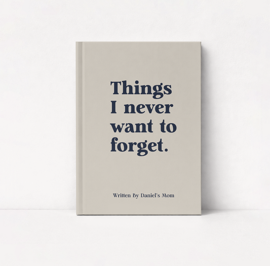 A hardcover boy mom keepsake journal with a light beige cover standing upright against a white background. The cover features the text 'Things I never want to forget.