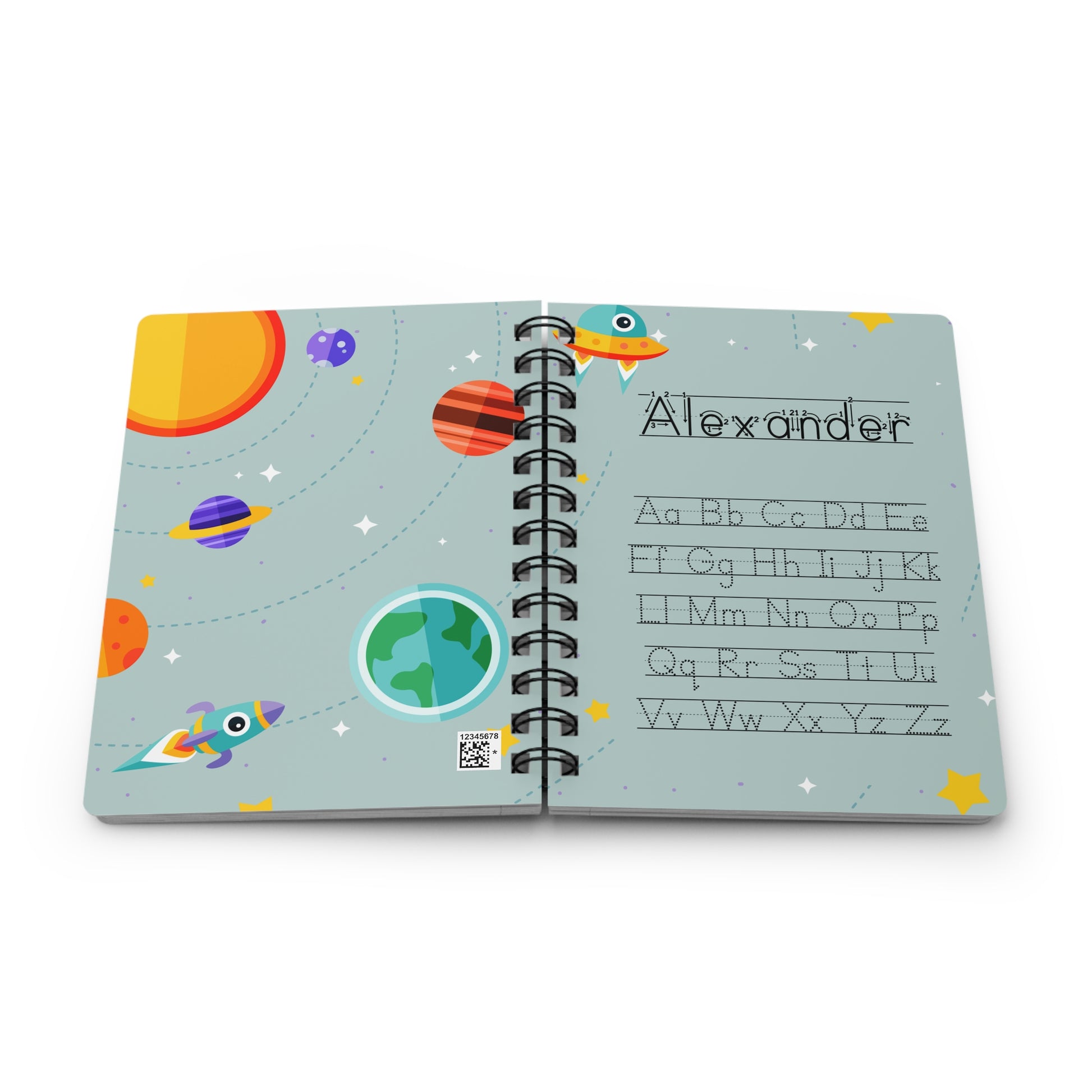 A personalized spiral-bound children's notebook with an outer space theme, featuring colorful planets, rockets, stars, and a custom name 'Alexander' with alphabet letters on the light blue cover, shown on a white background.
