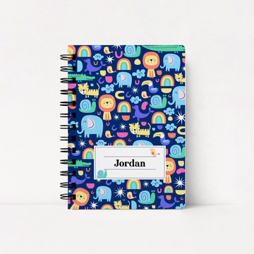A spiral-bound notebook with a colorful cartoon animal and rainbow pattern on a dark blue cover, featuring a white label that reads 'Jordan'.