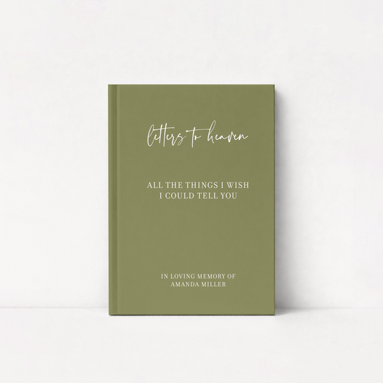 An olive green hardcover journal standing upright against a white background. The front cover features white text reading 'letters to heaven' in a cursive font, followed by 'ALL THE THINGS I WISH I COULD TELLYOU' and 'IN LOVING MEMORY OF AMANDA MILLER' in a serif font.