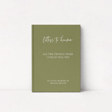 An olive green hardcover journal standing upright against a white background. The front cover features white text reading 'letters to heaven' in a cursive font, followed by 'ALL THE THINGS I WISH I COULD TELLYOU' and 'IN LOVING MEMORY OF AMANDA MILLER' in a serif font.