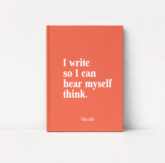 A coral orange hardcover book standing upright against a white background. The front cover features the white serif text 'I write so I can hear myself think.