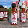 red gingham party favors miniature bottles of hot sauce